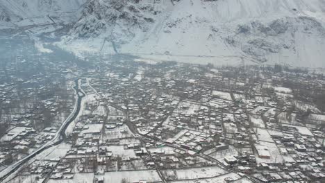 Panning-drone-view-of-snow-covered-crowded-Skardu-city,-Pakistan