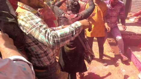 pov-shot-color-blowing-and-having-fun-and-many-people-are-sitting-on-the-side-where-people-are-blowing-color-with-color-or-pichkari