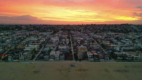 Manhattan-beach-coastline-and-Los-Angeles-city-with-fiery-sky,-aerial-view