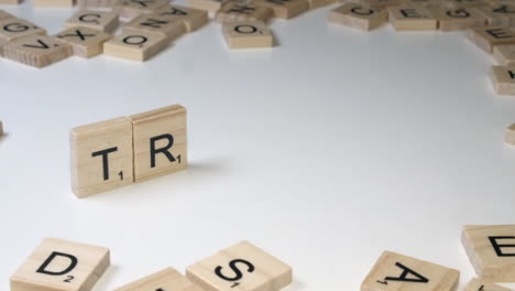 Closeup:-Scrabble-letter-tiles-on-edge-form-name-TRUMP-on-white-table