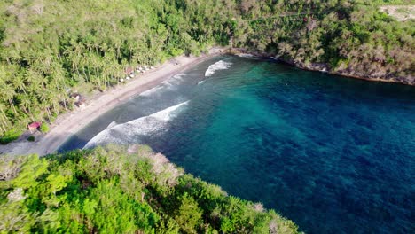 Vista-Aérea-De-La-Bahía-Turquesa-De-Gamat-Con-Olas-Y-Paraíso-De-Palmeras-Tropicales-En-La-Playa-De-Arena-En-Nusa-Penida,-Bali,-Indonesia