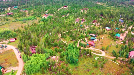 Aerial-Drone-Fly-Over-of-Isolated-Cabins-in-the-Middle-of-Nowhere-Surrounded-by-Pine-Tree-Forest-in-a-Hidden-Rural-Neighborhood-with-Dirt-Roads