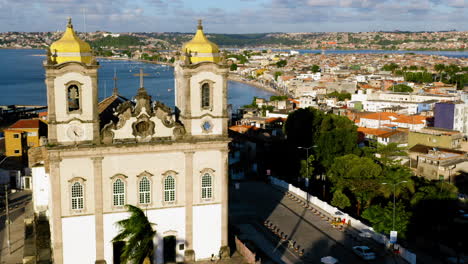 Aerial-view-of-Nosso-Senhor-do-Bonfim-church,-the-city-around-and-the-ocean-at-background,-Salvador,-Bahia,-Brazil