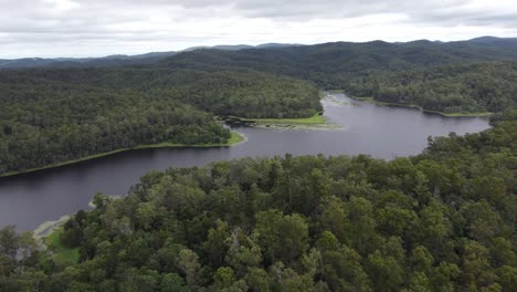4K-Aerial-view-of-water-reservoir-surrounded-with-thick-green-bushland