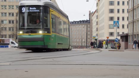 Low-angle-view-of-green-electric-transit-train-on-Helsinki-street-rail