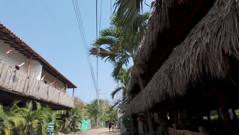 Thatched-roofs-line-Palomino's-tropical-street,-Colombia