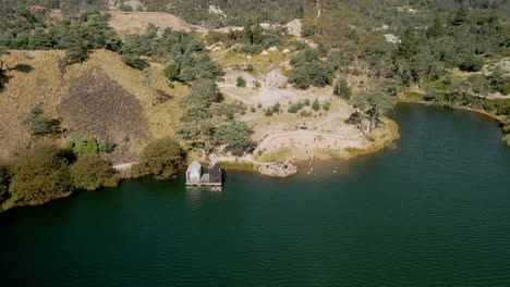 Antena-Inversa-De-La-Sauna-Flotante-Del-Lago-Derby-Con-Turistas-Nadando-En-La-Playa,-En-Derby,-Tasmania,-Australia