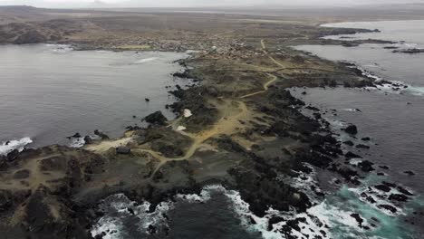 Rustic-golden-rocky-ocean-headland-at-Caleta-Chanaral-village-in-Chile