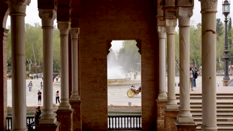 Touristen-Besuchen-Den-Berühmten-Platz-Mit-Typischen-Kutschen,-Coche-De-Caballos-Auf-Der-Plaza-De-Espana-In-Sevilla,-Spanien