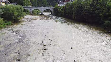 Drohnenflug-über-Eine-Historische-Steinbrücke-Und-Ein-Malerisches-Flussbett