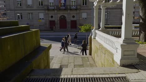 Friends-walk-along-sidewalk-path-by-San-Lazaro-Park-in-Downtown-Ourense-Spain