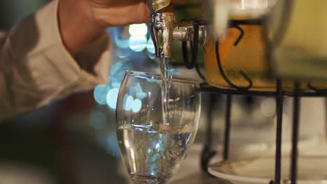 A-waiter-pours-water-into-a-wine-glass-during-wedding-banquet-service