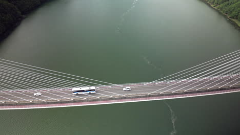 Overhead-Vortex-Aerial-of-Large-Bridge-Over-Green-Water
