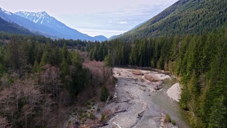 Beautiful-drone-view-of-Hansen-Creek-in-Evergreen-forest-with-mountains-in-the-background-in-Snoqualmie,-Washington-State