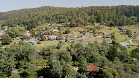 Tasmanian-town-of-Derby-drone-view-with-vacation-homes-and-wilderness-on-sunny-day,-Tasmania,-Australia