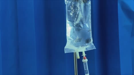 Intravenous-drip-administration-in-a-medical-facility-against-a-blue-background