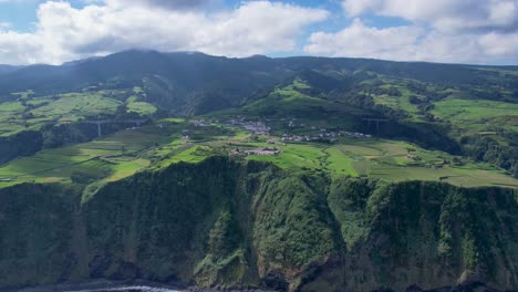 Aerial-hyperlapse-of-cloud-shadows-over-Algarvia-civil-parish-in-Nordeste,-dramatic-coastal-landscape-with-cliffs,-Sao-Miguel,-Azores