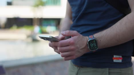 Close-up-of-man's-hands-holding-and-tapping-the-screen-of-a-smartphone