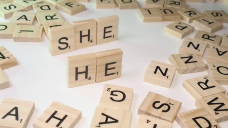 Pronoun-words-SHE-and-HER,-formed-with-Scrabble-letter-tiles-on-edge