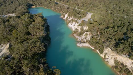 Aerial-panning-view-of-little-blue-lake-in-Tasmania,-Australia-during-sunny-day