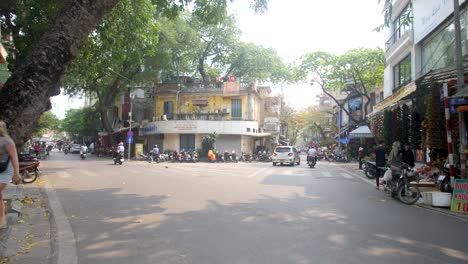 Downtown-centre-crossroads,-Motorcycles,-vehicles,-buildings-and-people