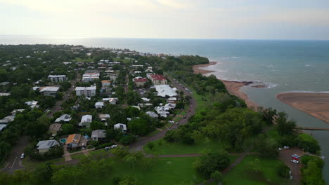 Drone-Aéreo-De-Rapid-Creek-Casuarina-Conduce-El-Tráfico-A-Lo-Largo-De-La-Curva-Frente-A-La-Playa-Por-La-Costa,-Retroceso