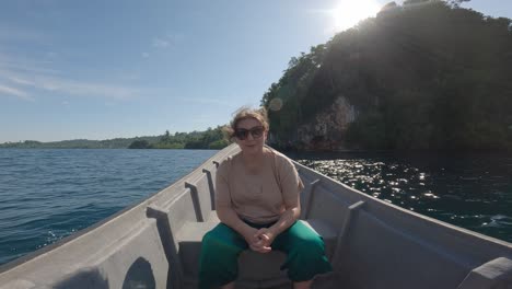 Una-Mujer-Feliz-Se-Sienta-En-La-Proa-De-Un-Barco-Navegando-Por-El-Famoso-Kali-Biru-En-Indonesia