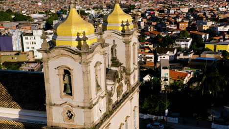 Aerial-view-of-Nosso-Senhor-do-Bonfim-church,-the-city-around-and-the-ocean-at-background,-Salvador,-Bahia,-Brazil