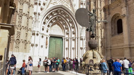 Menschen-Stehen-Schlange,-Um-Die-Kathedrale-Von-Sevilla-Zu-Besichtigen---Statue-Der-Giraldillo---Sonniger-Tag
