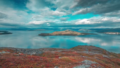 Stormy-clouds-above-the-fjord-and-tundra-whirl-in-a-timelapse-video-backlit-by-the-sun,-creating-a-stark-contrast-with-the-calm-surroundings-of-autumn