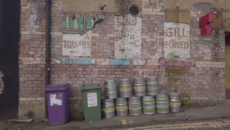 Eine-Reihe-Von-Bierfässern-Und-Verblasste-Werbung-Vor-Einem-Pub-In-Glasgow