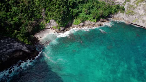 Atemberaubender-Strand,-Umgeben-Von-Bewachsenen-Felsformationen-Und-Türkisfarbenem-Wasser-In-Nusa-Penida,-Bali,-Indonesien