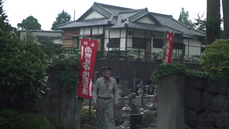 Kamera-Folgt-Zwei-Japanischen-Männern-In-Arbeitskleidung-Beim-Verlassen-Eines-Friedhofs-In-Fujikawaguchiko