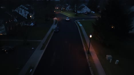 Car-driving-through-dark-American-neighborhood-during-night