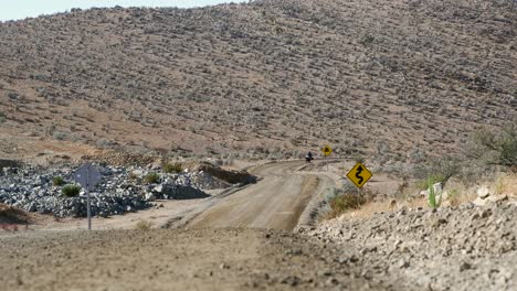 Motorcyclist-approaches-camera-on-rustic-remote-gravel-road-in-Chile