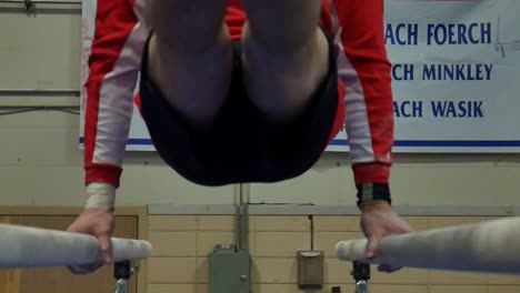 Person-does-a-gymnastics-trick-on-the-parallel-bars