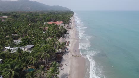 Dolly-Aéreo-Sobre-Turistas-Y-Familias-Jugando-En-Tranquilas-Playas-De-Arena-De-Palomino-Colombia