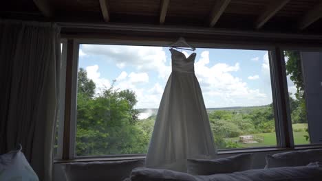 Bride's-dress-hanging-on-the-open-window-of-the-room-with-a-view-of-the-landscape-of-the-Iguazu-Falls
