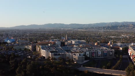 Wide-aerial-dolly-shot-of-Universal-Studios-Hollywood-at-sunset-in-Los-Angeles,-California