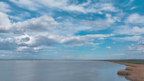 Drone-hyperlapse-over-a-lake-showing-white-clouds-drifting