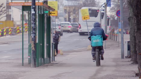 Radfahrer,-Der-Essen-An-Kunden-Ausliefert,-Radelt-Auf-Dem-Bürgersteig-Der-Stadt-In-Helsinki