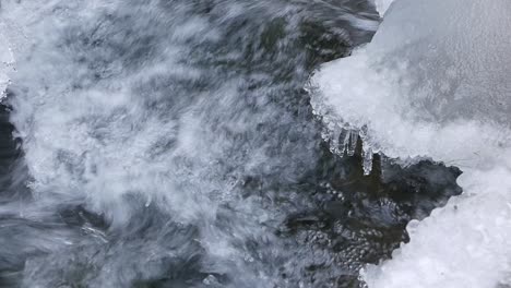 Fluss-Fließt-An-Eisbedeckten-Felsen-Vorbei