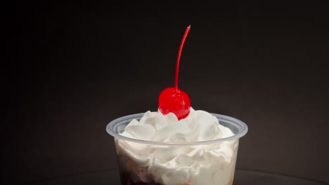 close-up-detail-shot-Chocolate-cream-cup-parfait-cherry-on-top-spinning-in-turntable-with-black-background-copa-nevada