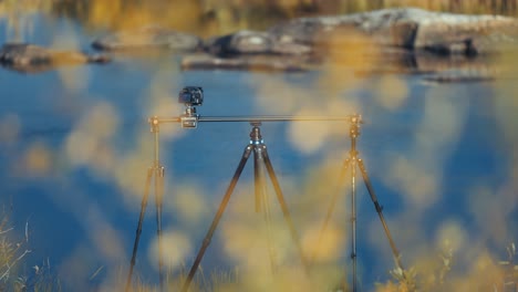 A-professional-camera-on-the-slider-rig-stands-on-the-bank-of-the-river