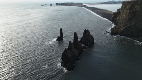 Drohne-Nach-Unten-Kippen-über-Reynisdrangar-Seastacks-Von-Reynisfjara-Schwarzen-Sandstrand