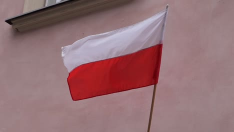 Polnische-Flagge-Weht-An-Einem-Fahnenmast-An-Einer-Hauswand-Im-Wind