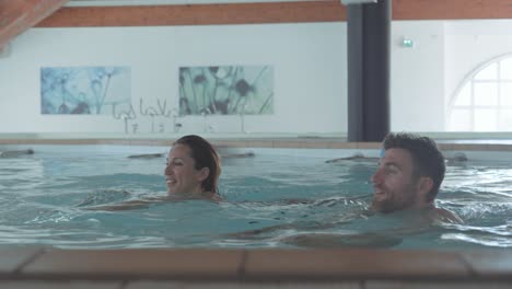 Slow-motion-shot-of-a-couple-swimming-breaststroke-together-in-a-spa-pool