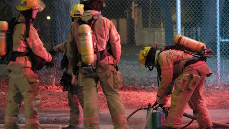 Feuerwehrleute-Wischen-Ihre-Ausrüstung-Nach-Einem-Feuerwehreinsatz-In-Montreal-Ab-Und-Spülen-Sie-Ab