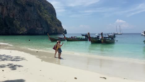 Tourists-walking-in-exotic-monkey-beach-in-Phi-Phi-islands