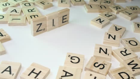 Hand-forms-pronoun-words-ZIE-and-HIR-in-game-tile-letters-on-table-top